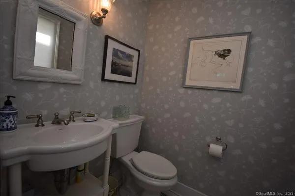 a bathroom with a toilet a sink and mirror