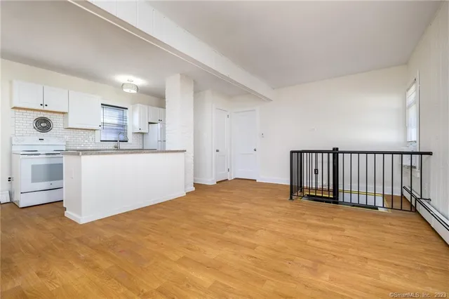 a kitchen with stainless steel appliances granite countertop a stove a sink and white cabinets