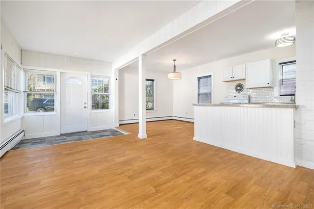 a view of a kitchen with wooden floor and a window