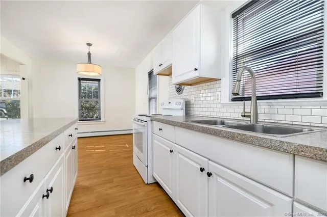 a view of kitchen with stainless steel appliances granite countertop a sink and cabinets