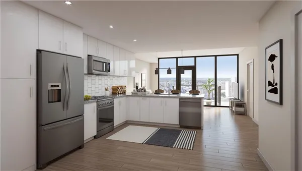 a kitchen with a refrigerator a sink and white cabinets with wooden floor