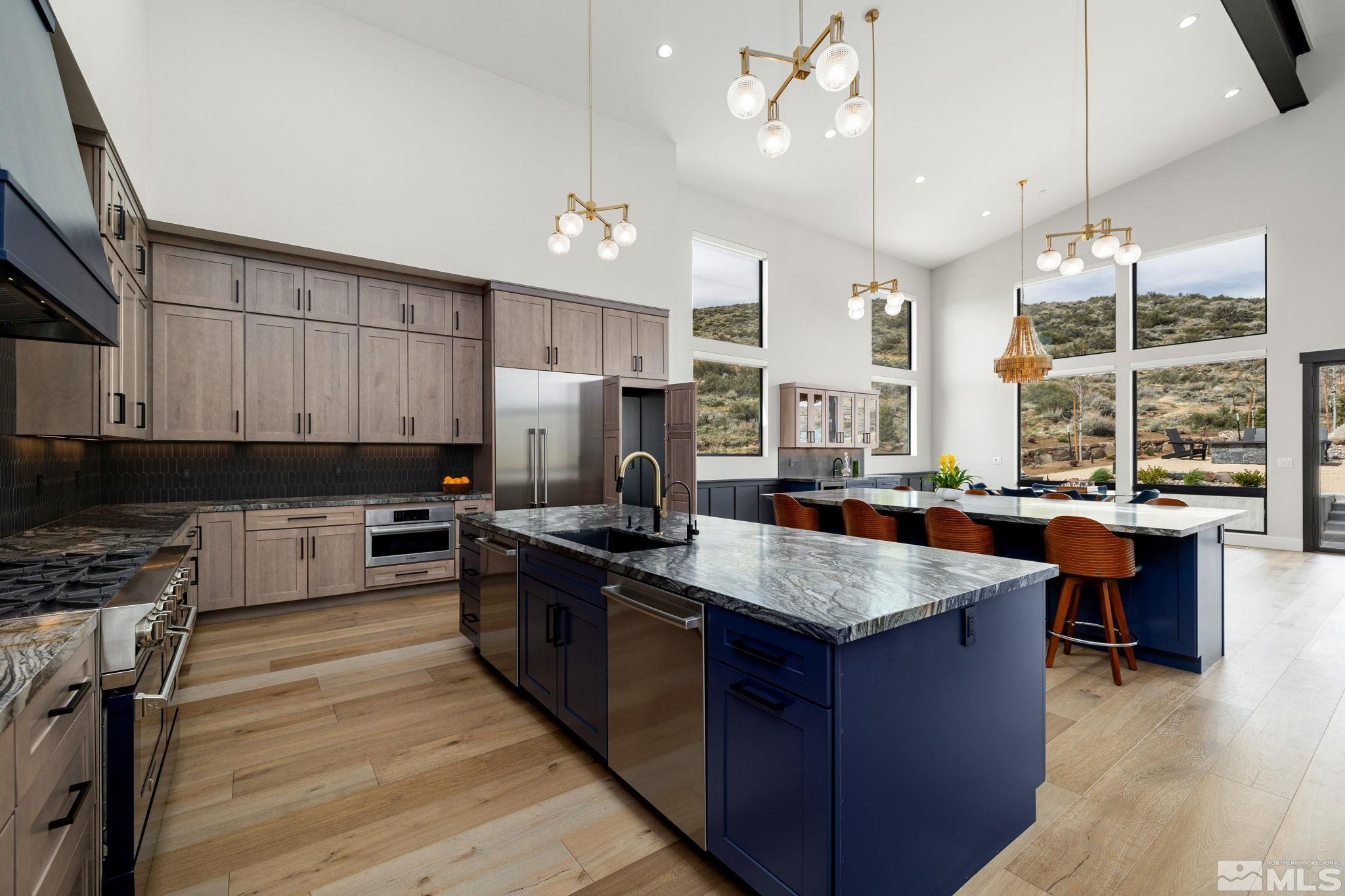 4225 Drop Tine Court Reno, NV 89511 - Photo 7 of 14 a kitchen with stainless steel appliances granite countertop a stove a sink dishwasher a microwave oven and a dining table with wooden floor