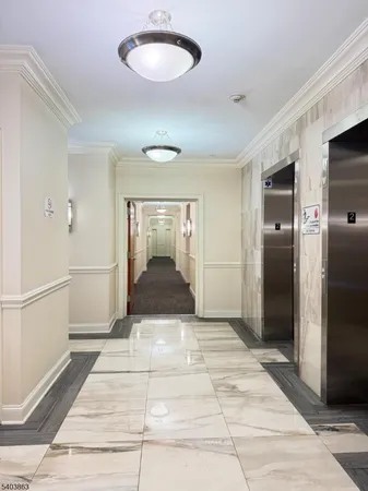a view of a hallway with wooden floor and a living room