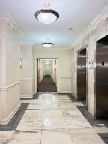a view of a hallway with wooden floor and a living room