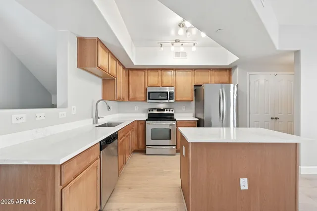 a kitchen with stainless steel appliances granite countertop a refrigerator stove top oven a sink and dishwasher