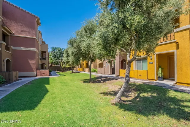 a view of a backyard with a table and chairs and a large tree