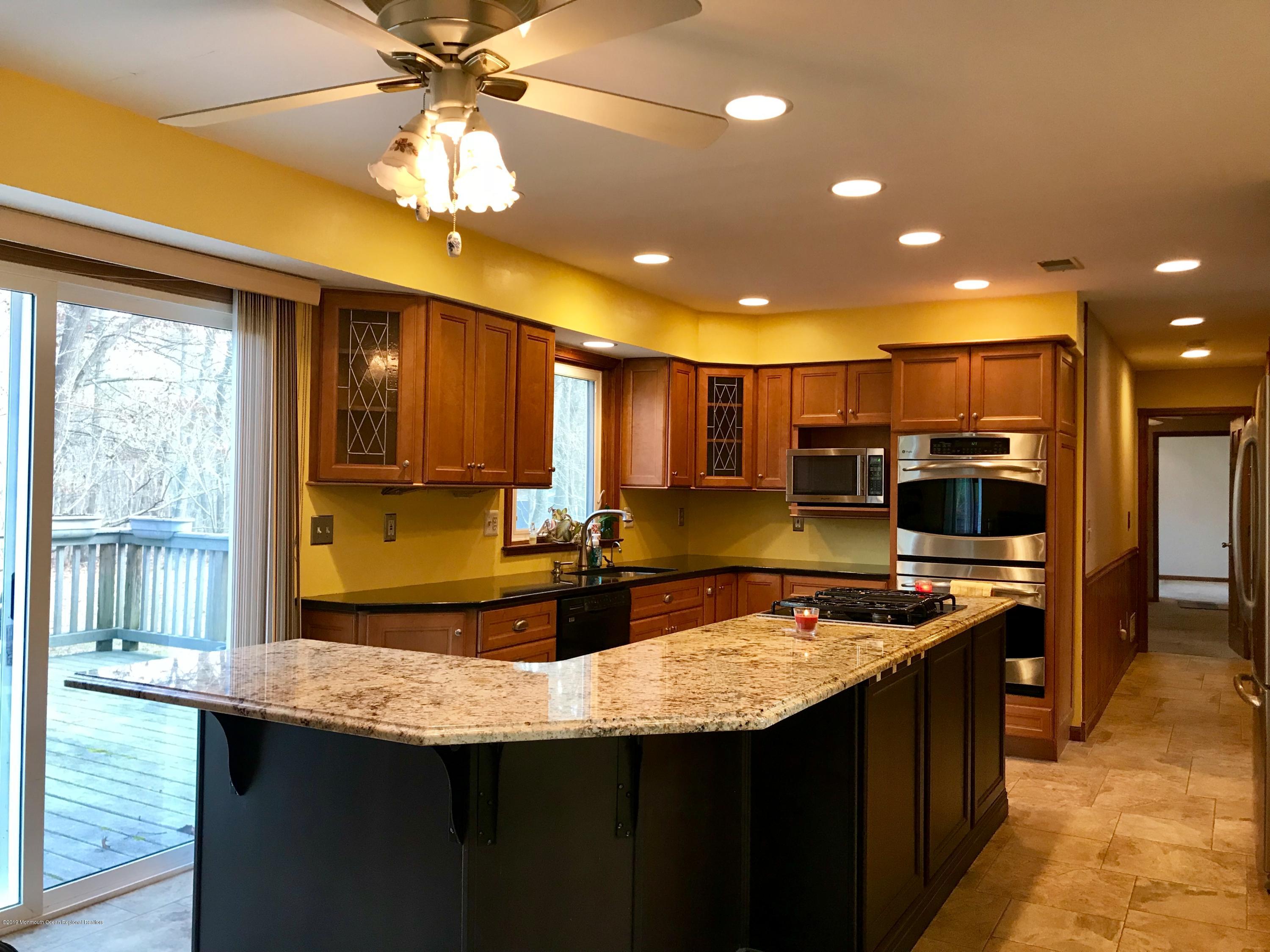 17 Dunhill Road Jackson, NJ 08527 - Photo 13 of 28 a kitchen with kitchen island a sink and a stove top oven with wooden floor