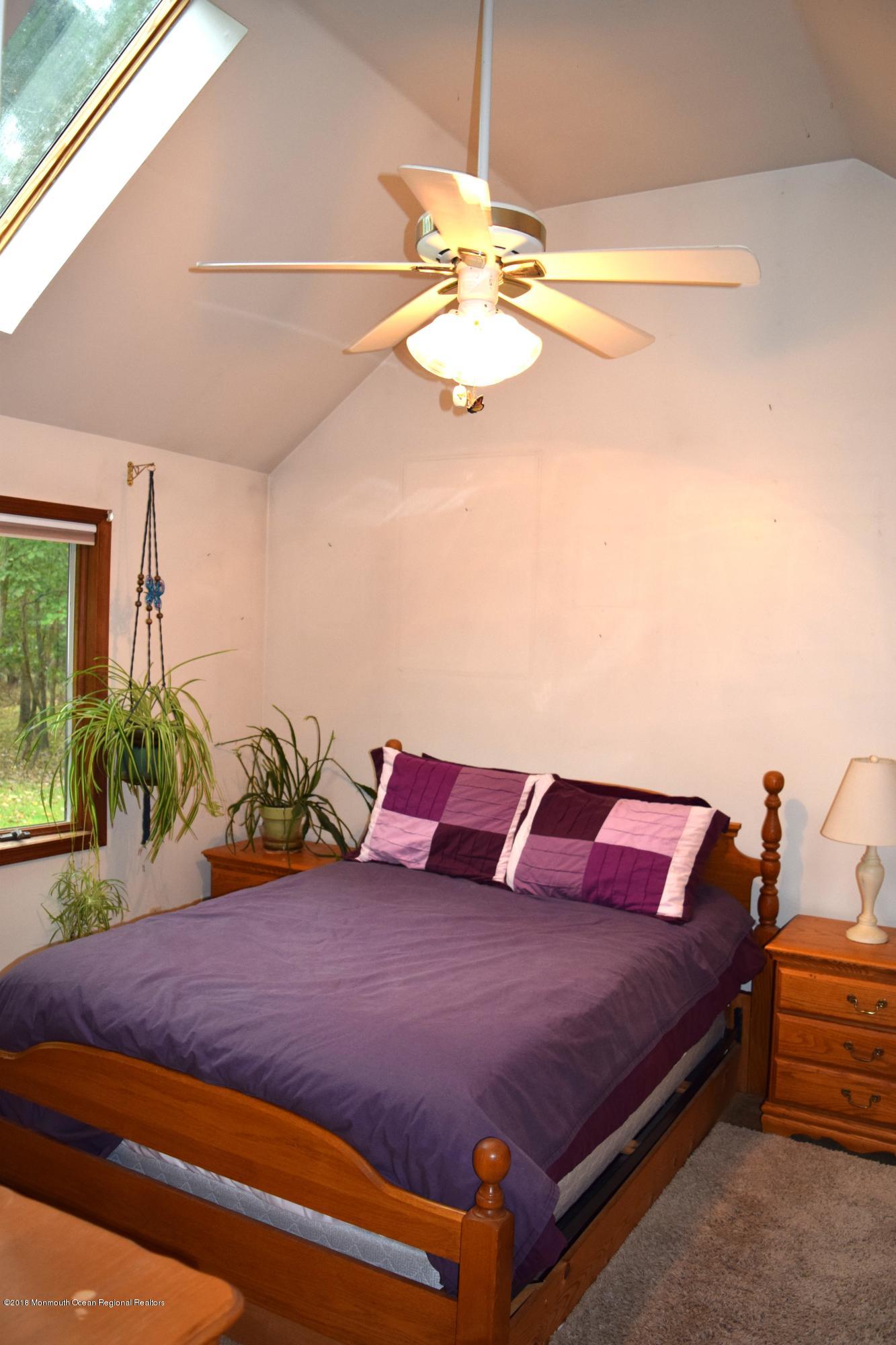 17 Dunhill Road Jackson, NJ 08527 - Photo 15 of 28 a bedroom with a bed and chandelier