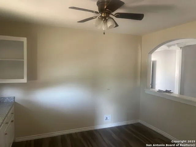 en empty room with wooden floor and windows