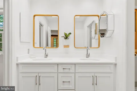 a bathroom with double vanity sinks and a mirror