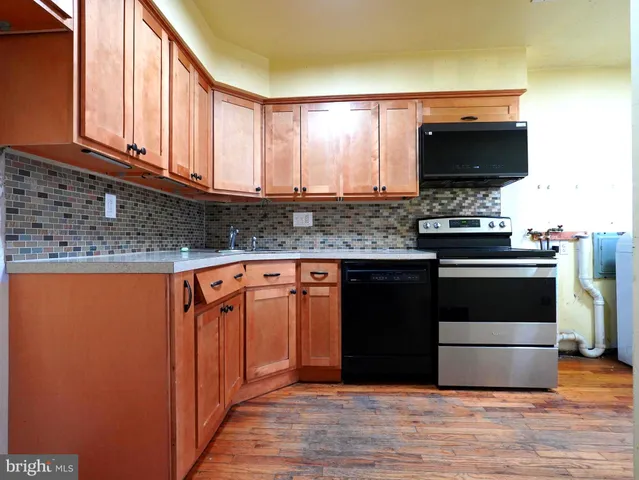 a kitchen with stainless steel appliances granite countertop a stove top oven microwave and cabinets