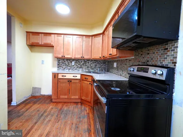 a kitchen with a sink and wooden floor