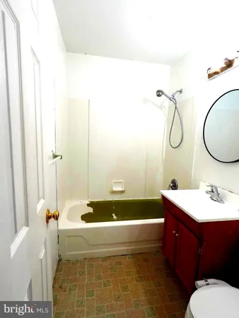 a bathroom with a sink a toilet a mirror and bathtub
