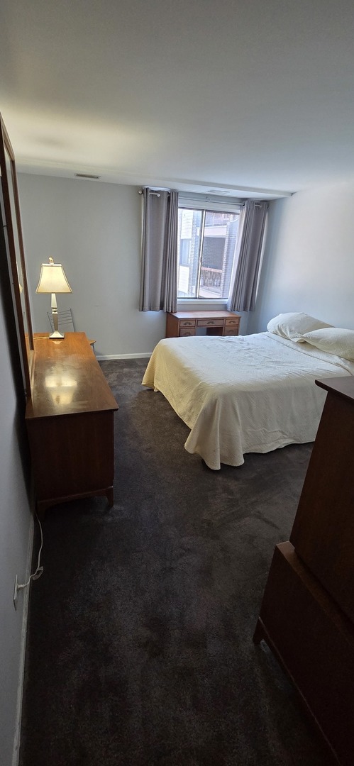 450 Raintree Court, Unit 2M Glen Ellyn, IL 60137 - Photo 14 of 25 a bed sitting in a bedroom next to a window