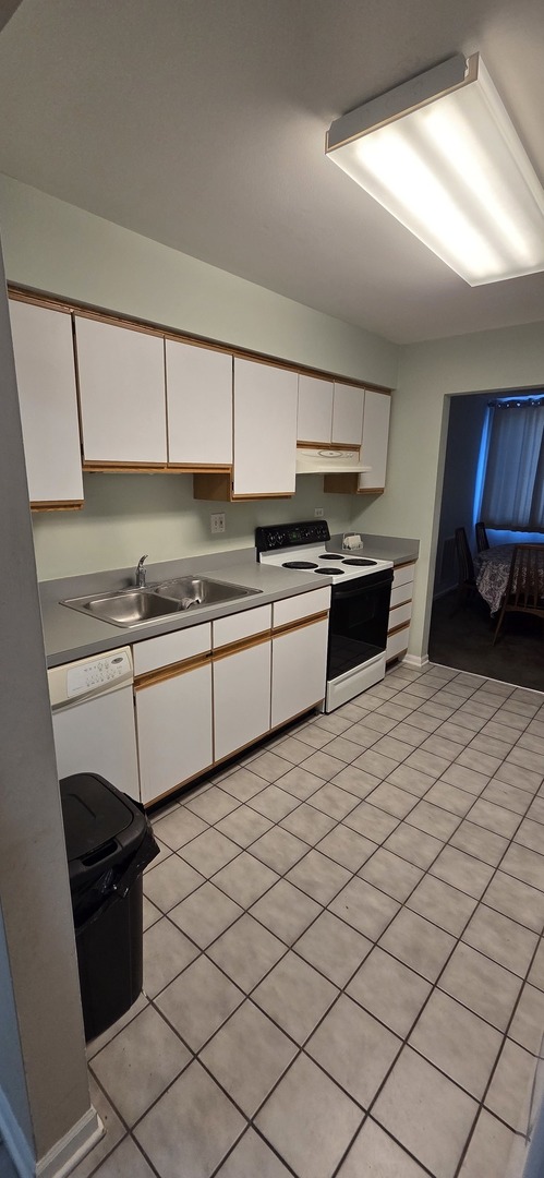 450 Raintree Court, Unit 2M Glen Ellyn, IL 60137 - Photo 24 of 25 a kitchen with stainless steel appliances kitchen island granite countertop a sink dishwasher stove top oven and cabinets