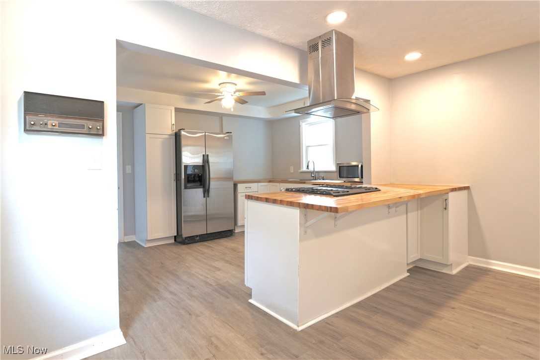 1332 South Green Road South Euclid, OH 44121 - Photo 7 of 23 Kitchen with wood counters, a peninsula, white cabinets, stainless steel appliances, and a kitchen bar