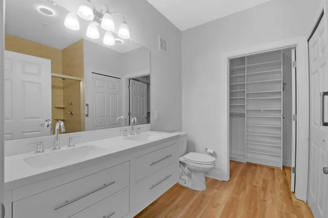 a bathroom with a double vanity sink mirror and toilet