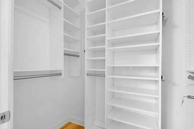 a view of walk in closet with empty racks