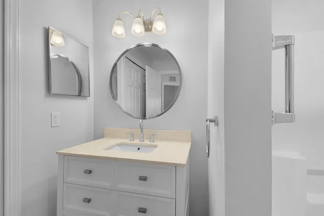 a bathroom with a sink mirror and vanity