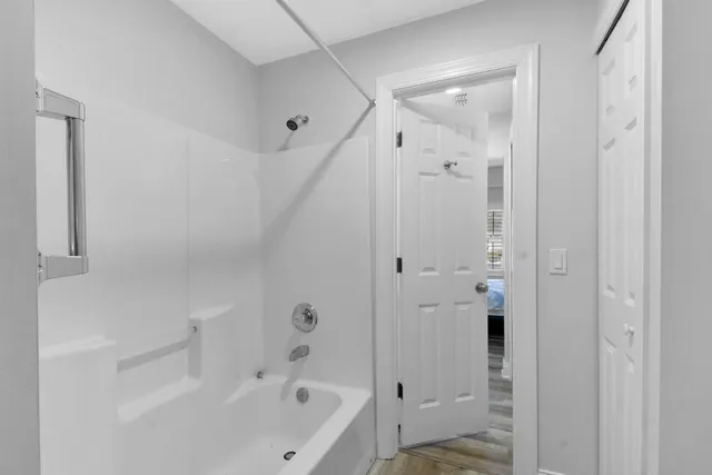 a bathroom with a bathtub shower and a sink