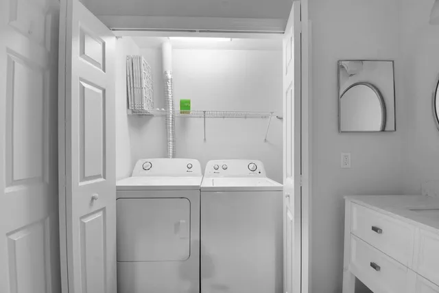 a view of a hallway with wooden floor and a bathroom