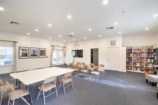 a living room with furniture a table and kitchen view