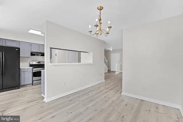 a view of a kitchen with refrigerator and wooden floor