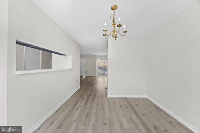 a view of a room with wooden floor and chandelier