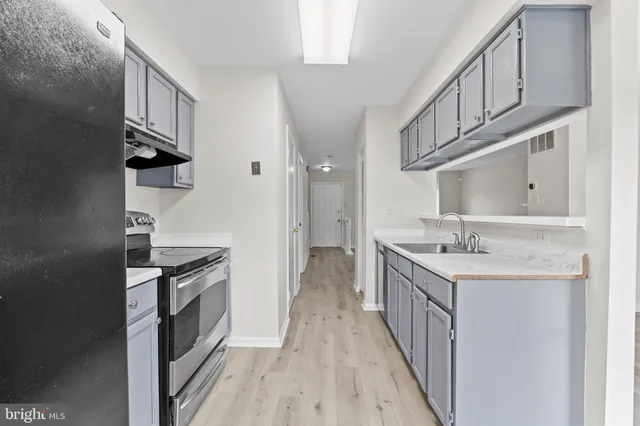 a kitchen with stainless steel appliances granite countertop a sink and a stove top oven