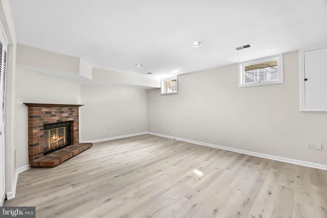 a view of empty room with wooden floor and fireplace