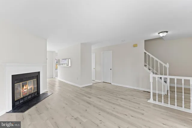 a view of an empty room with a fireplace and a window