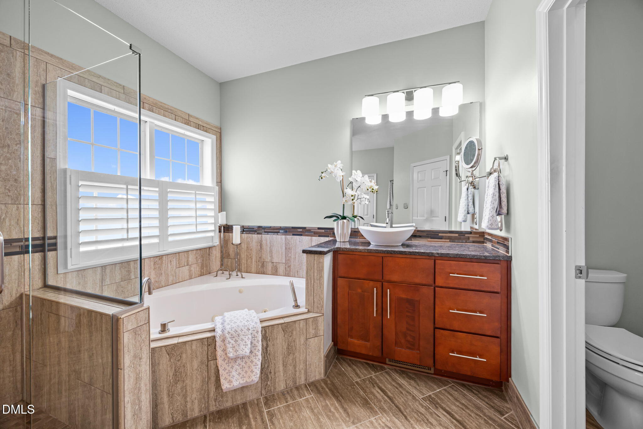 5501 Southern Cross Avenue Raleigh, NC 27606 - Photo 17 of 43 a bathroom with a tub a double vanity sink and a large mirror