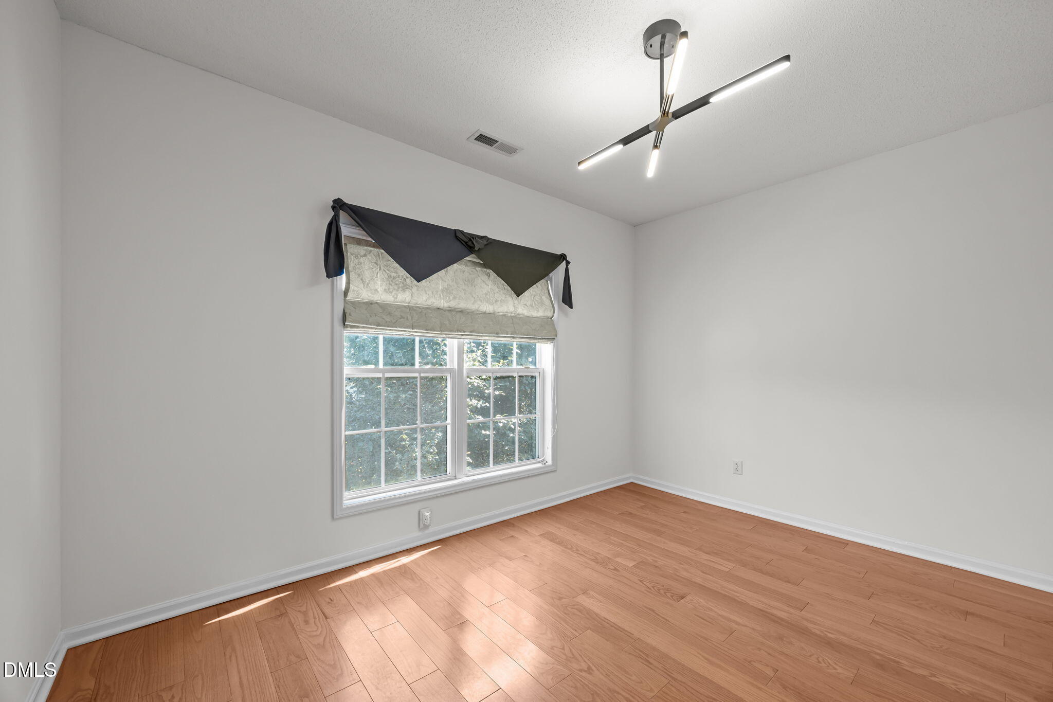 5501 Southern Cross Avenue Raleigh, NC 27606 - Photo 23 of 43 an empty room with wooden floor cabinet and windows
