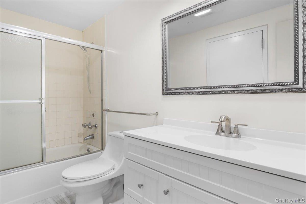 100 Cutter Mill Road, Unit 3F Great Neck, NY 11021 - Photo 32 of 33 a bathroom with a sink a mirror a toilet and shower
