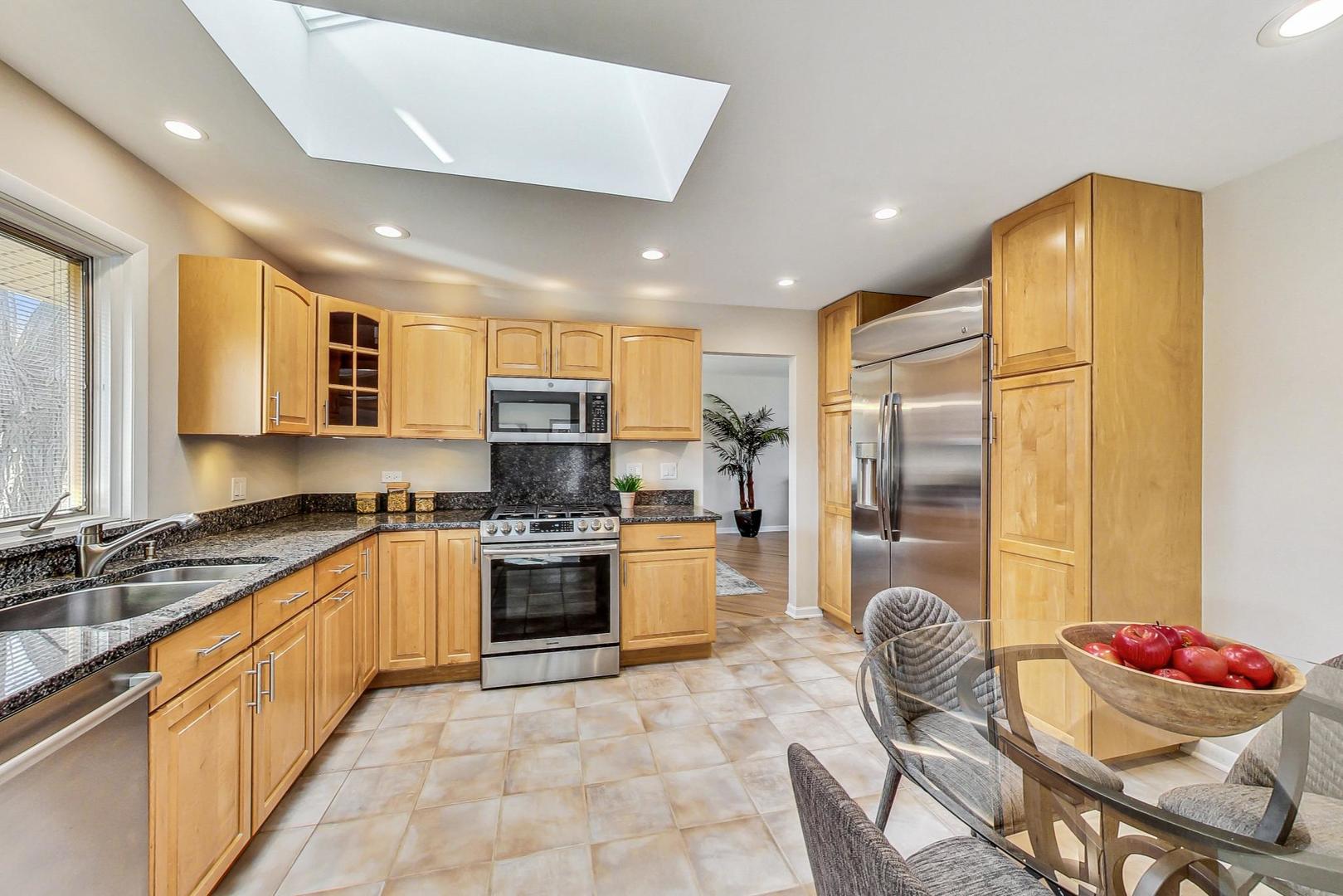 1724 Larkdale Road Northbrook, IL 60062 - Photo 7 of 31 a kitchen with stainless steel appliances granite countertop a sink refrigerator and cabinets