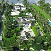 an aerial view of a residential houses with yard and green space