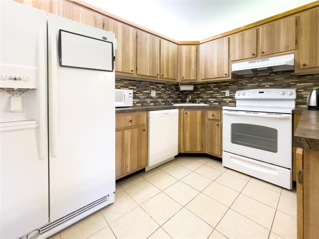 330 Knotty Pine Circle, Unit A1 Greenacres, FL 33463 - Photo 6 of 30 a kitchen with stainless steel appliances a stove a microwave and a refrigerator