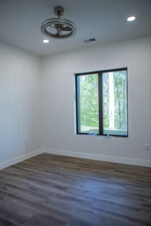 a view of a room with wooden floor and a window