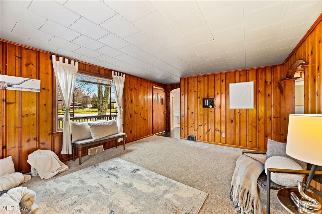 4556 Fishcreek Road Stow, OH 44224 - Photo 6 of 41 Carpeted living room featuring wood walls and arched walkways