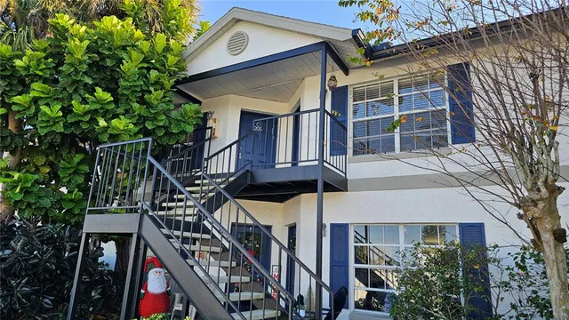 a front view of a house with a tree