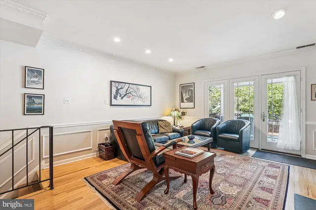 a view of a patio with two couches and table with wooden floor and fence