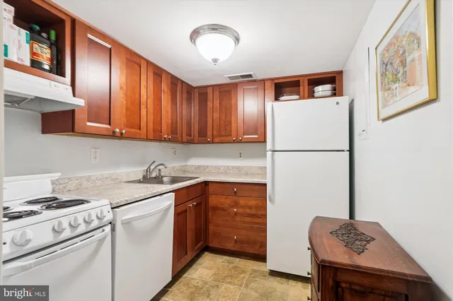a kitchen with a refrigerator sink and cabinets