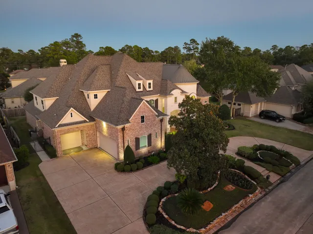an aerial view of a house with a yard fire pit and outdoor seating