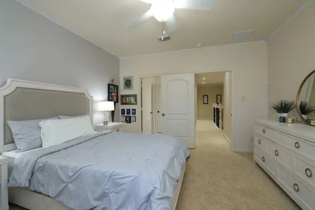 a bedroom with a bed and a chandelier fan