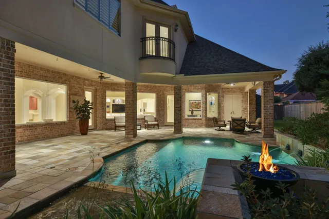 a view of a swimming pool with lawn chairs under an umbrella