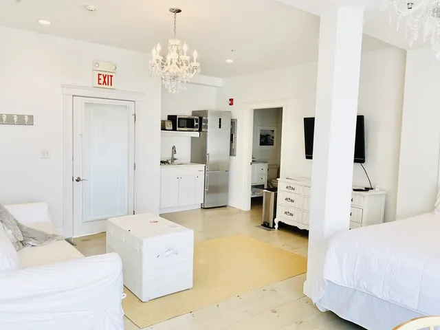 a spacious bedroom with a bed and a chandelier