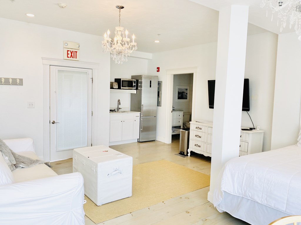 4 Bay Street, Unit A0 Hull, MA 02045 - Photo 14 of 23 a spacious bedroom with a bed and a chandelier