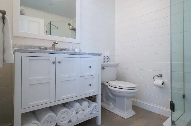 a bathroom with a granite countertop toilet sink and mirror