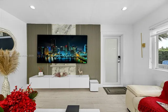 a living room with furniture a flat screen tv and a fireplace