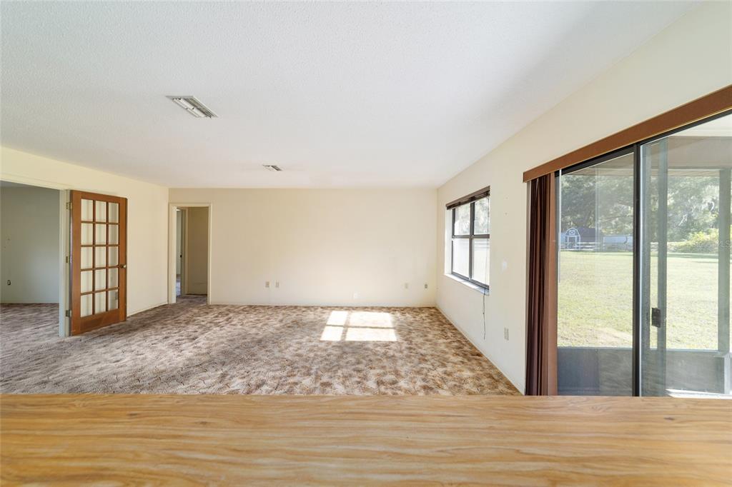 10700 Southeast Sunset Harbor Road Summerfield, FL 34491 - Photo 22 of 41 a view of an empty room with window and wooden floor